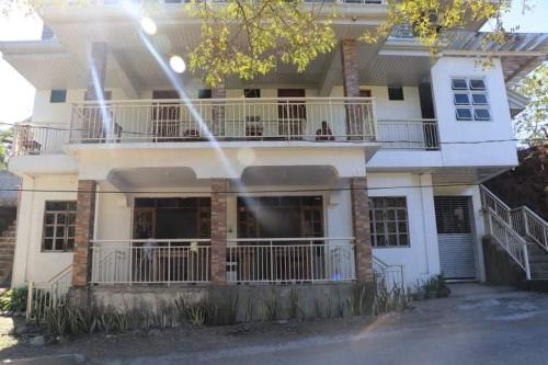a large white house with a balcony on top of it at capitol hills apartelle in Mamburao