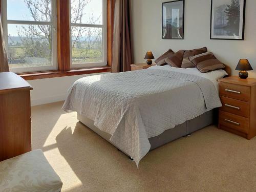 um quarto com uma cama grande e 2 janelas em Buckieburn em Banknock