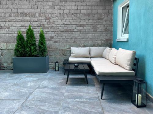 a couch sitting on a patio next to a brick wall at Nurban Apartments Oldtown in Nuremberg