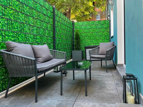 a patio with chairs and a table and a green fence at Nurban Apartments Oldtown in Nuremberg