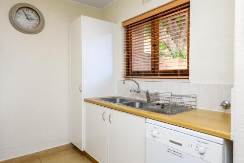 a kitchen with a sink and a clock on the wall at San Lameer Villa 2536 - 3 Bedroom Superior - 6 pax - San Lameer Rental Agency in Southbroom