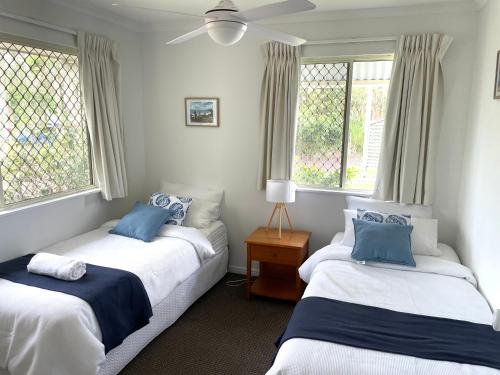 2 Betten in einem Zimmer mit 2 Fenstern in der Unterkunft 2 Bedroom Ground Level Villa in Tropical 4* Resort in Noosaville