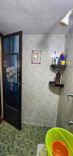 y baño con ducha, puerta y lavamanos. en JJ's Holiday Home en Thanniyam