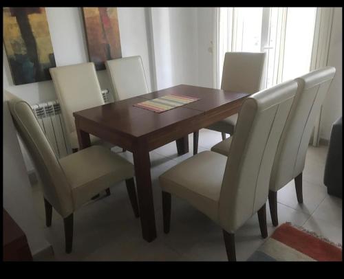 a dining room table with white chairs and a wooden table at PJA2-LT Bonita Villa localizado en La Torre Golf Resort in Torre-Pacheco