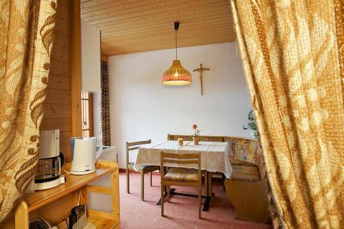 a dining room with a table and a cross on the wall at Angerle Alm Apt Zwergenvolk in Carezza al Lago