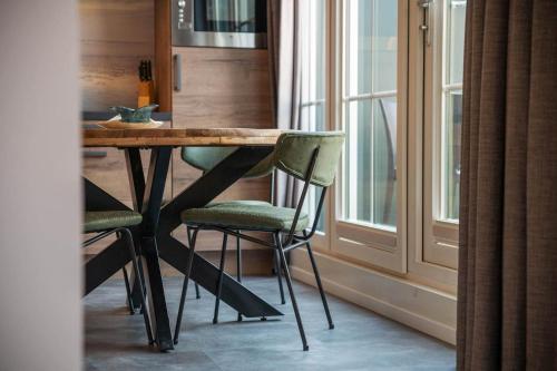 a kitchen with a wooden table and chairs next to a window at Appartementen De Witte Brugh in Buren
