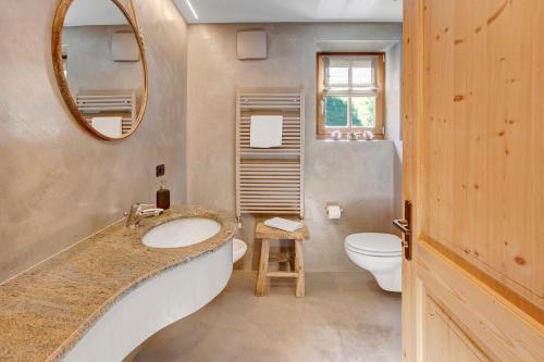 ein Badezimmer mit einem Waschbecken, einem WC und einem Spiegel in der Unterkunft Chalet Sonne Superior2 4 in Livigno