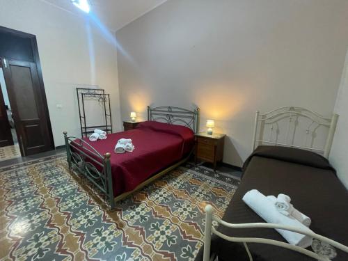 una camera con un letto rosso e un tappeto di Maya Palace Real Rooms Palermo centre close to Cathedral a Palermo