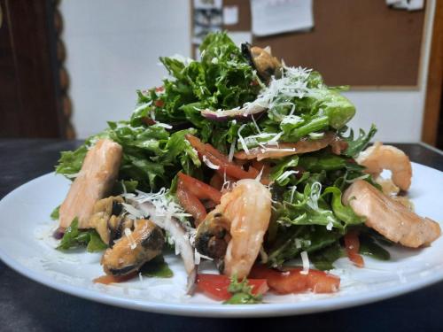 a plate of food with a salad on a table at Eventhaus Schamin in Erpen
