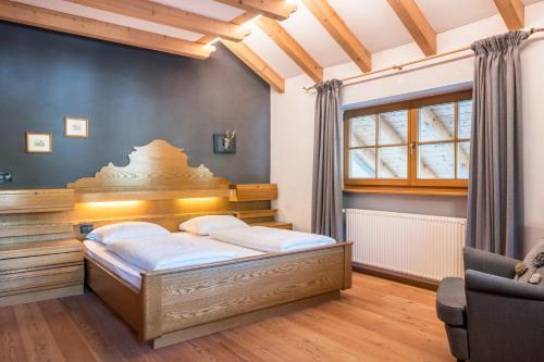 1 dormitorio con 1 cama y 1 silla en Lotschenhof Apt Margerite, en Trodena