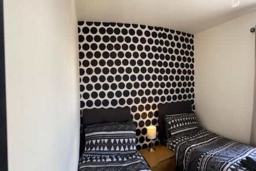 a bedroom with two beds and a black and white patterned wall at Wilson 74 in Darlington