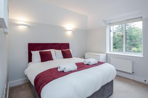 a bedroom with a large bed with towels on it at Roomspace Serviced Apartments - Lomond Court in Surbiton