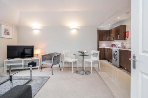 a living room with a table and a kitchen at Roomspace Serviced Apartments - Lomond Court in Surbiton