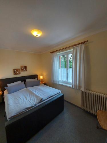 ein Schlafzimmer mit einem großen Bett und einem Fenster in der Unterkunft Gasthof & Appartementhaus Meyer in Annaberg