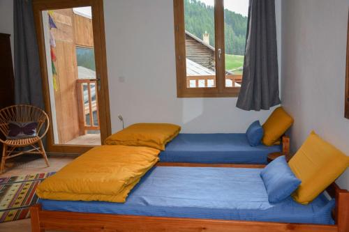 two beds in a room with a window at Nepal en Queyras in Molines-en-Queyras