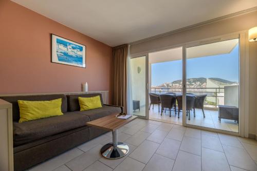 a living room with a couch and a table at Best Western Plus Ajaccio Amirauté in Ajaccio