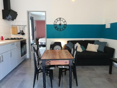 a table and chairs in a living room with a couch at La Dame de cœur 05 in Antonaves