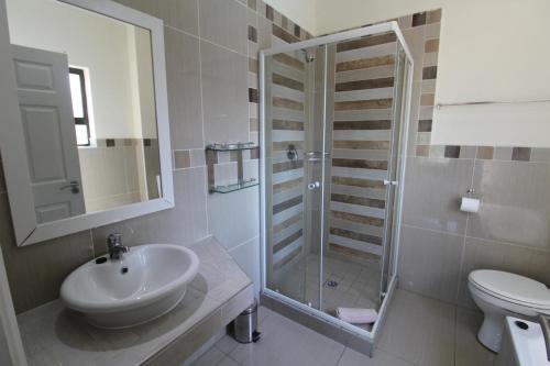 ein Bad mit einer Dusche, einem Waschbecken und einem WC in der Unterkunft Saints View Resort Unit 6 in Uvongo Beach