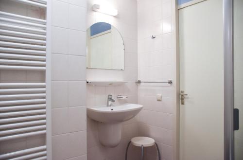 a white bathroom with a sink and a mirror at Libra 19 in Nes