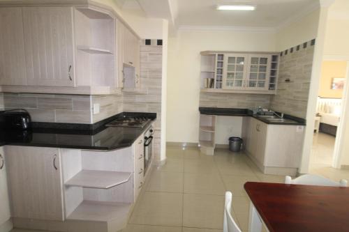 une cuisine avec des placards blancs et un comptoir dans l'établissement Saints View Resort Unit 7, à Uvongo Beach