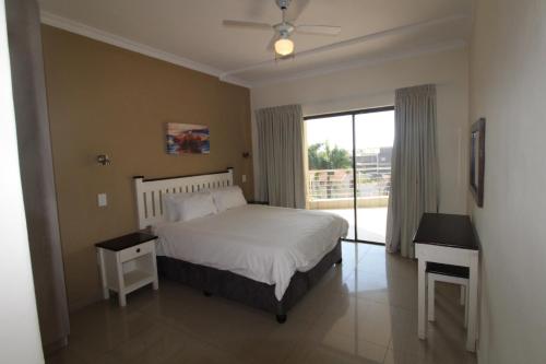 a bedroom with a bed and a large window at Saints View Resort Unit 7 in Uvongo Beach