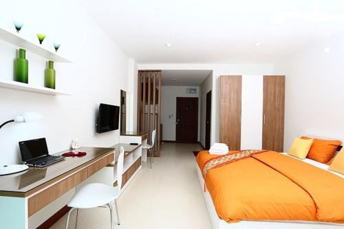 1 dormitorio con 1 cama y escritorio con ordenador portátil en Smart Mansion, en Min Buri