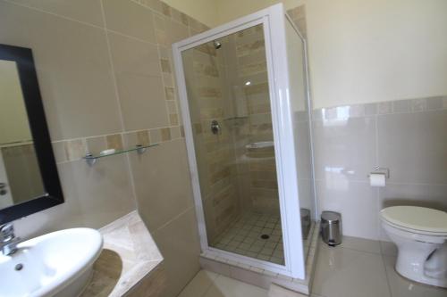 a bathroom with a shower and a toilet and a sink at Saints View Resort Unit 9 in Uvongo Beach