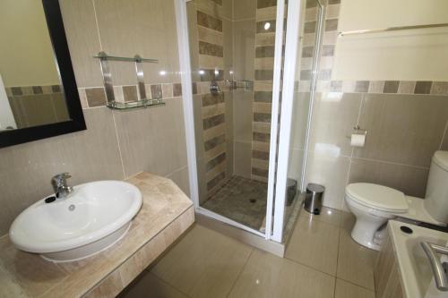 a bathroom with a sink and a shower and a toilet at Saints View Resort Unit 12 in Uvongo Beach