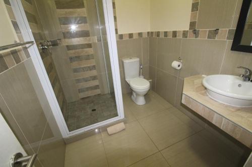 a bathroom with a shower and a toilet and a sink at Saints View Resort Unit 12 in Uvongo Beach