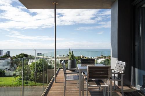 a balcony with a table and chairs and a view of the ocean at Premier Hotel Umhlanga in Durban