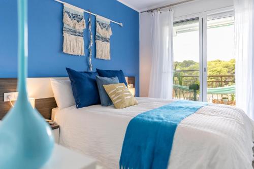 a blue bedroom with a bed with blue walls and a window at Beach Front Retro Hideaway in Salou in Salou