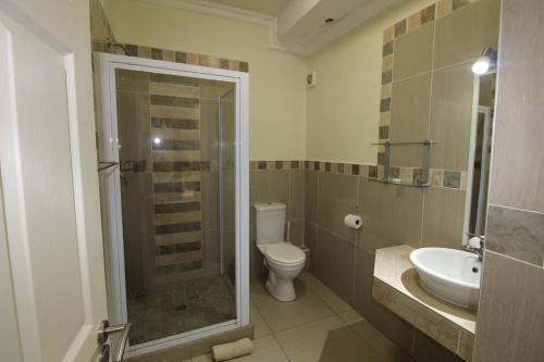 ein Bad mit einer Dusche, einem WC und einem Waschbecken in der Unterkunft Saints View Resort Unit 13 in Uvongo Beach