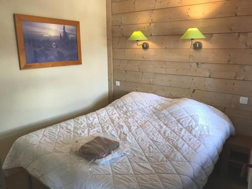 a bedroom with a bed with two lamps on the wall at Appartement La Tania, 2 pièces, 5 personnes - FR-1-513-78 in La Tania