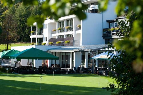 a hotel with tables and umbrellas in front of a building at Das Vesper in Sprockhövel