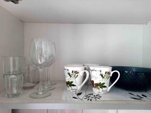eine Theke mit zwei Tassen und einem Glas Wein in der Unterkunft Апартаменты Амстердам проспект Богдана Хмельницкого in Dnipro