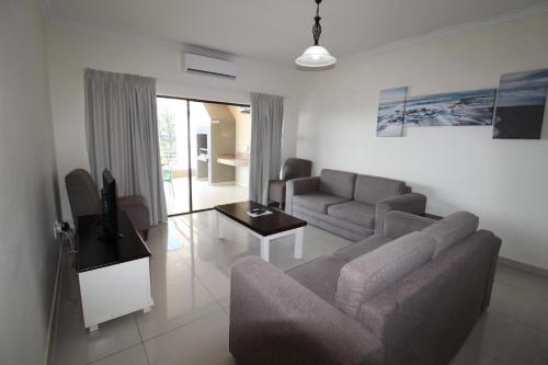 a living room with a couch and a tv in it at Saints View Resort Unit 21 in Uvongo Beach