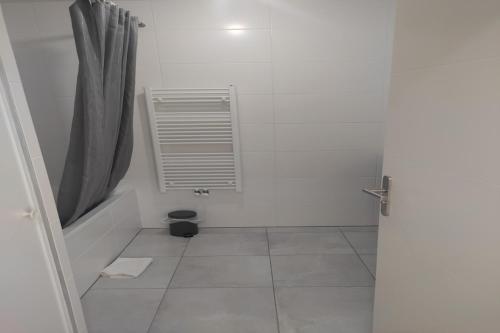 une salle de bains blanche avec une fenêtre et un radiateur dans l'établissement Super Appart 4 p - à 5 min Disneyland, à Chessy