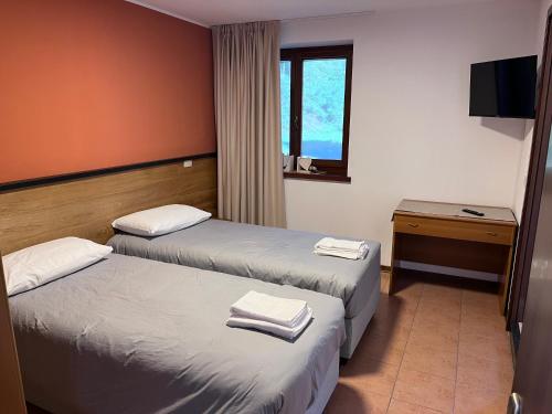 a hotel room with two beds and a window at Al Friuli in Nimis
