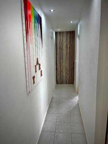 a hallway with paintings on the wall and a hallway with a hallwayngthngthngth at Plumeria Hébergement Tiare in Grand-Bourg