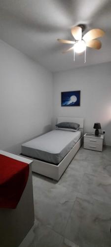 a bedroom with a bed and a ceiling fan at Lovely 3-bedroom apartment in Marsalforn, Gozo! in Marsalforn