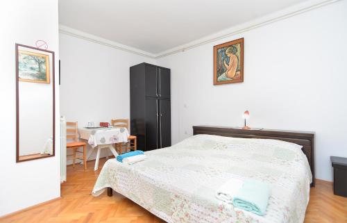 a bedroom with a large bed and a table at Rooms Veli Vrh 2208 in Pula