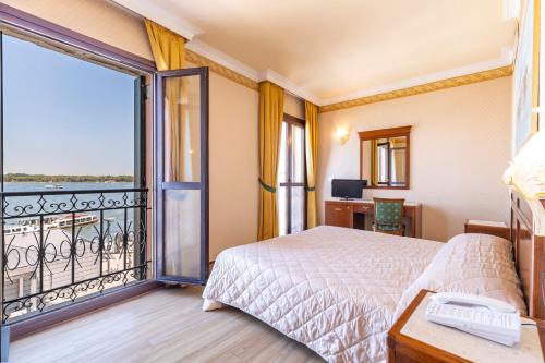 a hotel room with a bed and a balcony at Hotel Panorama in Venice-Lido