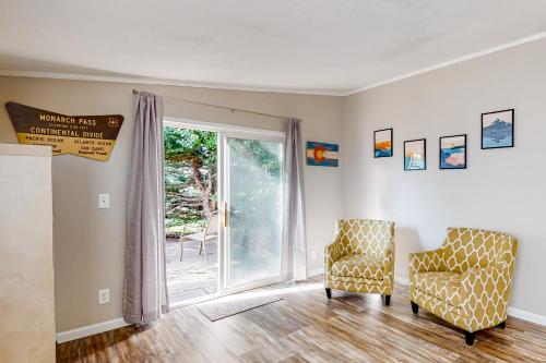 a living room with two chairs and a sliding glass door at Resting Wildflower in Gunnison