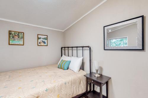 a bedroom with a bed and a mirror and a table at Resting Wildflower in Gunnison