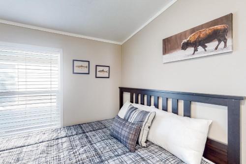 a bedroom with a bed and a picture of a cow on the wall at Resting Wildflower in Gunnison
