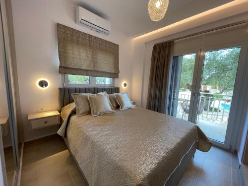 a bedroom with a bed and a large window at Villa Niva in Ayios Kirikos