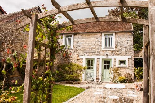 a stone cottage with an archway in front of it at Gîtes Isatis in Arbonne-la-Foret