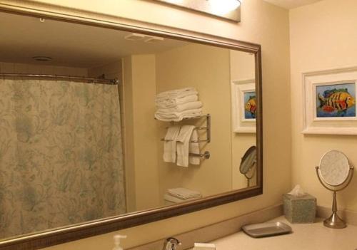 a bathroom with a large mirror over a sink at Oceanfront Studio Condo With Balcony View Of Beach And Ocean In Daytona Beach Resort 1011 With 4 Pools Tiki Bar Grill in Daytona Beach