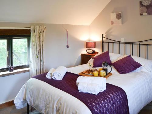 a bedroom with a large bed with towels on it at Eden Cottage in Little Hautbois