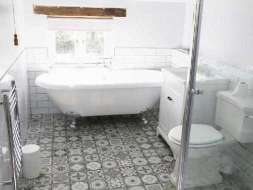 Eden Cottage في Little Hautbois: حمام أبيض مع حوض ومرحاض